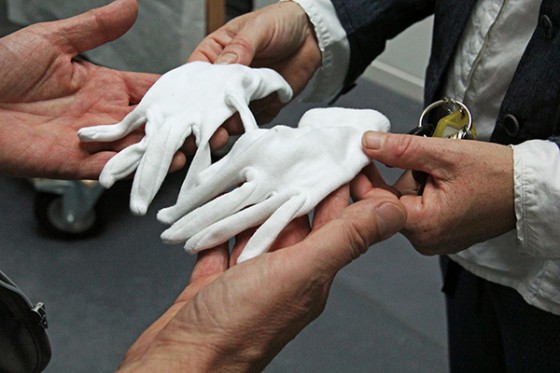 Vier Hände und ein Paar weiße Handschuhe