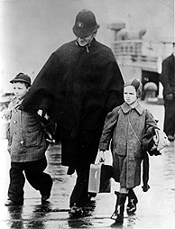 A British police officer with two children after the arrival of a children's transport, Harwich, Essex, United Kingdom, 12 December 1938