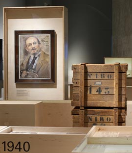 Gemälde und Holzkisten in der Ausstellung
