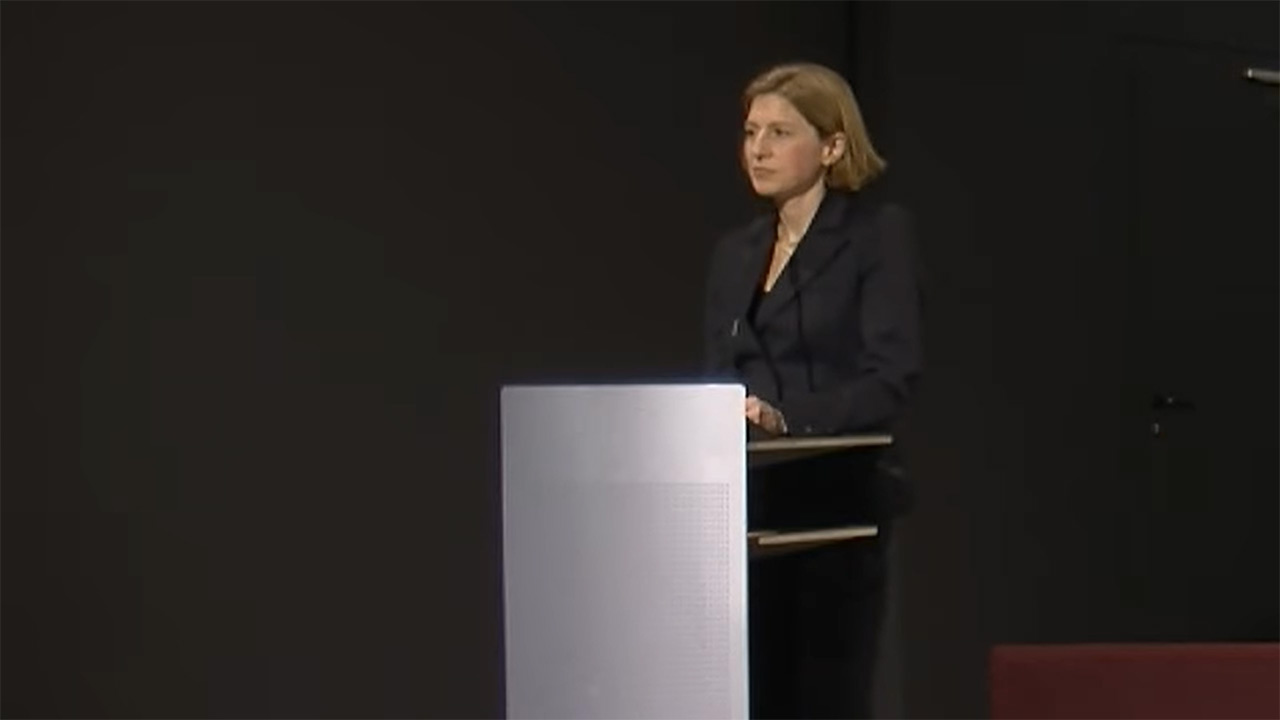 Woman stands at the lectern and speaks.