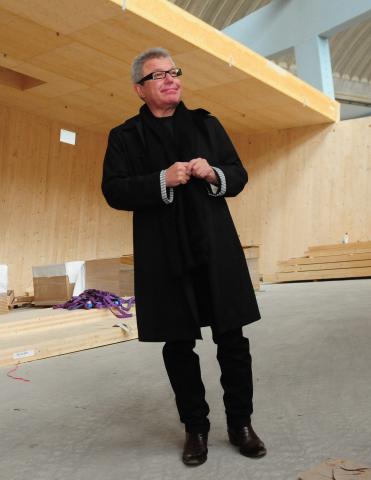 Ein schwarz gekleideter Mann (Daniel Libeskind) auf der Baustelle.