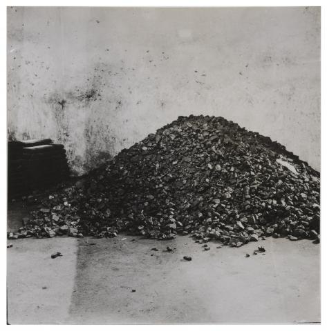 Schwarz-Weiß Foto eines Kohlehaufens in einem Kohlenkeller