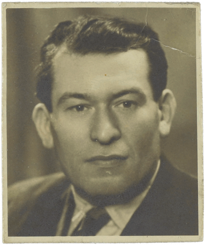 Schwarz-weiß Portrait eines weißen Mannes mit zurückgekämmten Haaren.