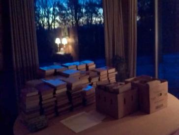Piles of books lie on a table.