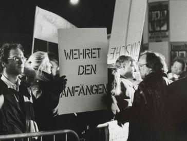 Schwarz-Weiß-Fotografie von Protestierenden mit Plakaten mit Aufschriften wie "Wehret den Anfängen".