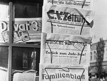 Black and white photograph of a newspaper rack.