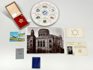 A golden five-pointed star with a hammer and sickle, a seder plate, a postcard from Glowe, a photo of the ruined synagogue in Oranienburger Straße and various identity papers