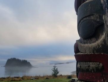 Photography of a totem pole in a foggy landscape with lake 