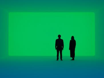 A man and a woman stand in a room flooded with green light.