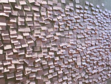 An einer Wand kleben zahlreiche Post-Its.