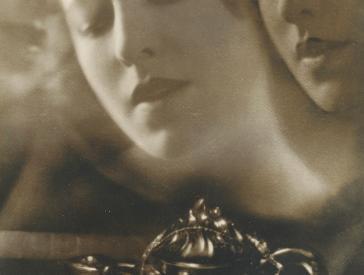 Schwarz-Weiß-Fotografie einer Frau, deren Gesicht geisterhaft noch einmal neben ihr schwebt.