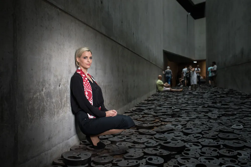 A young woman sitting in the Memory Void of the Jewish Museum Berlin