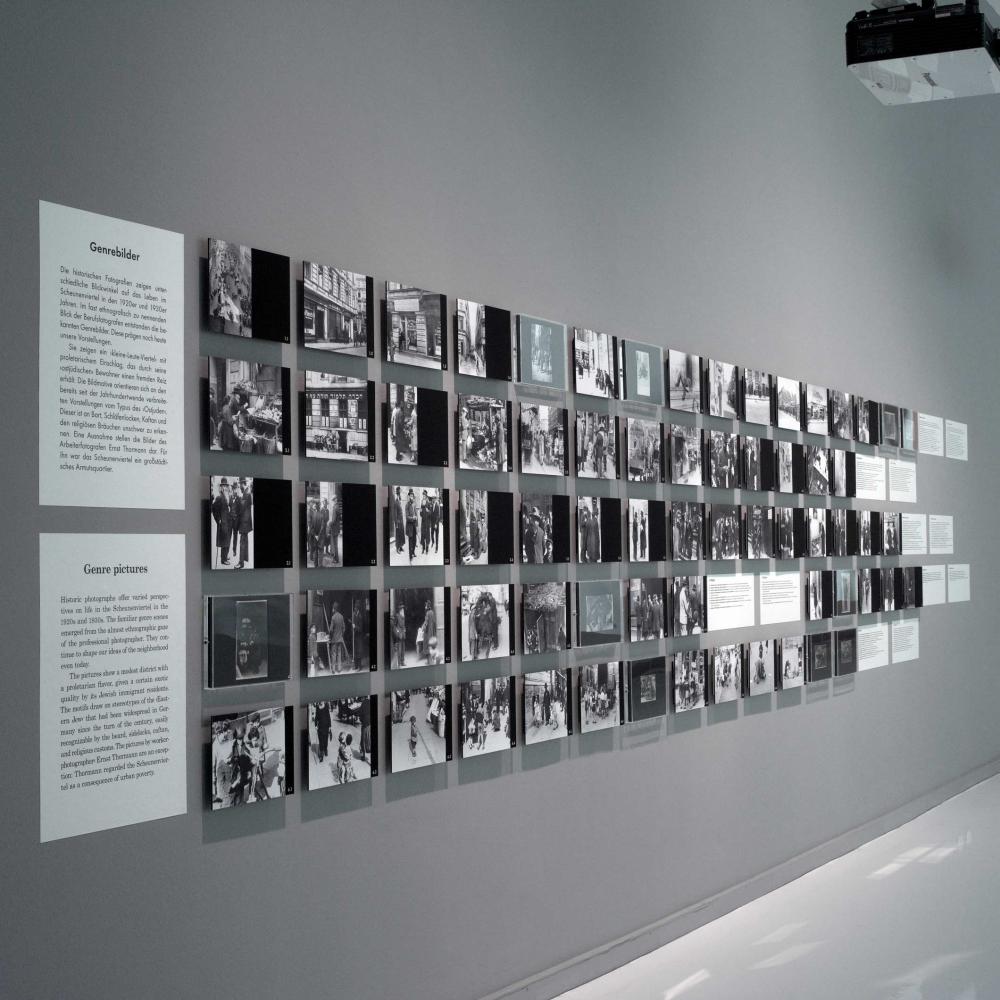 Wall with multiple black-and-white photos that are hanged in multiple long rows