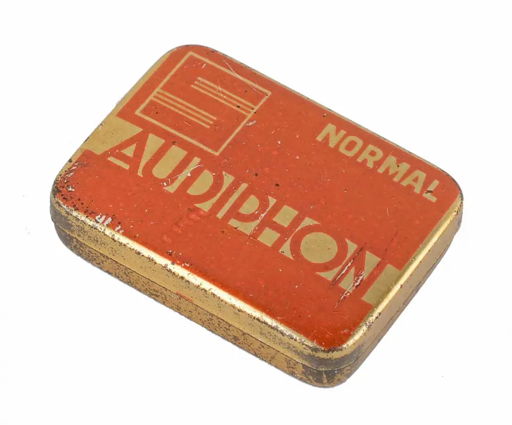 Goldfarbene Dose, deren Deckel ist in rostroter Farbe gehalten und trägt die Aufschrift Audiophon.