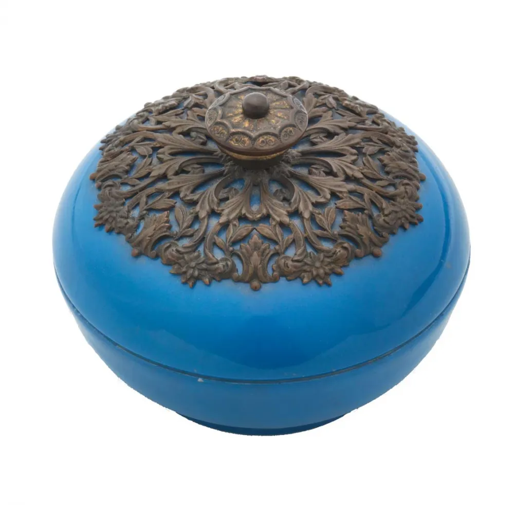 Runde blaue Porzellandose mit metallenem Deckelgriff in Pflanzenmuster.