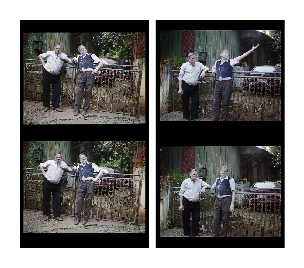 A four pannel repeated black and white scene of two older men with large grey mustaches leaning against a rusting fence