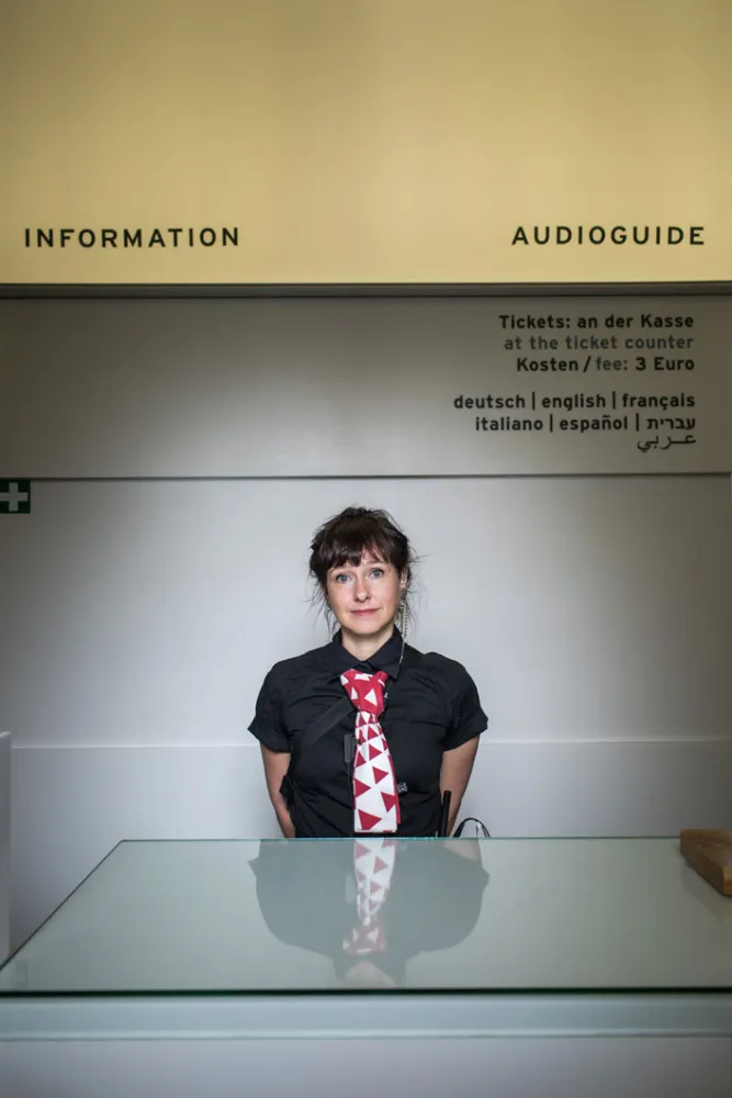A young woman stands at the Infopoint of the Jewish Museum Berlin