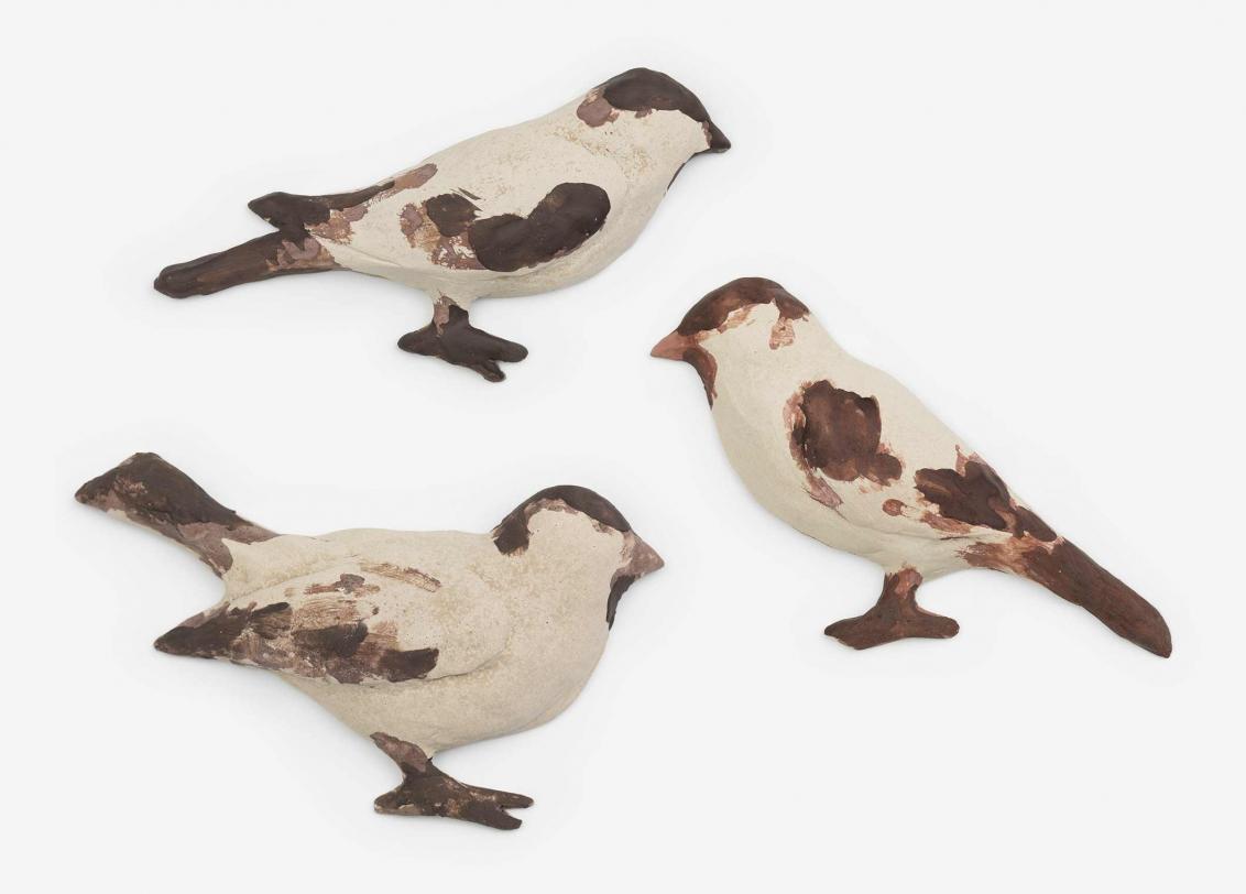 Three sculptures of brown and white birds