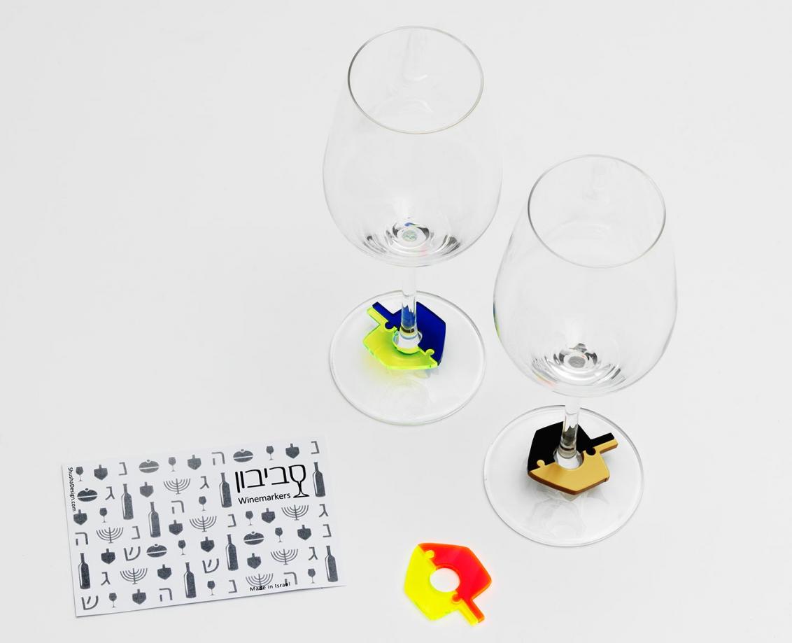 Two wineglasses with colorful dreidel-shaped charms around their stems