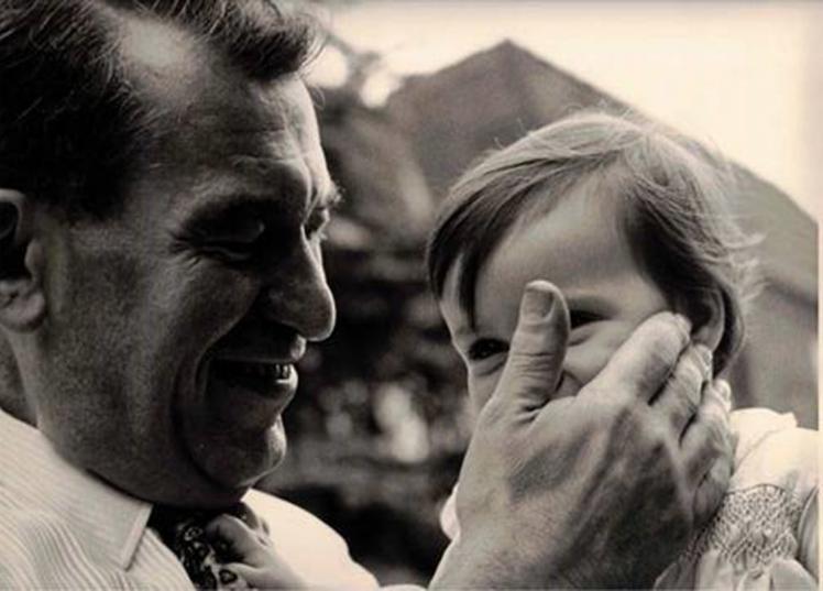 Black and white photo, close-up: a father lovingly strokes his daughter's face.