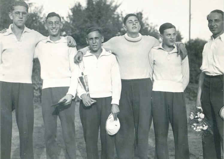 Black-and-white photograph of a rowing team holding a trophy