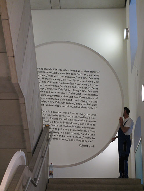 Die Texttafel mit dem titelgebenden Zitat aus Kohelet 3,1-8 wird in die Ausstellung gebracht
