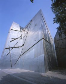 View of the titanium-zinc facade of the Libeskind building, which is broken up by slanting lines.