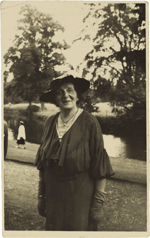 Historical black and white photograph of an elderly lady wearing a hat.