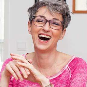 A woman laughs into the camera.