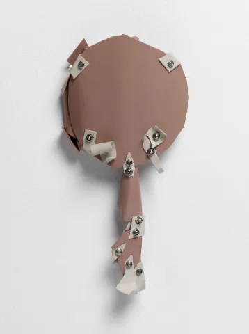 Light brown object shaped like a hand mirror, on which beige smaller areas are attached with rivets.