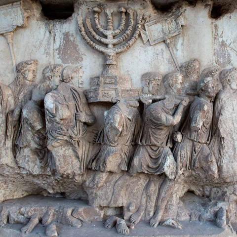 Damaged relief: a group of men carrying a Hanukkah candelabrum on their shoulders.