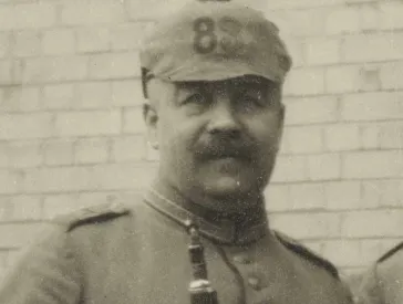 Black and white portrait of a man with a spiked helmet.