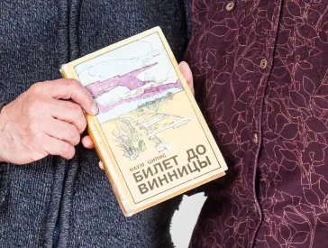 Elderly man and elderly lady holding a book together.