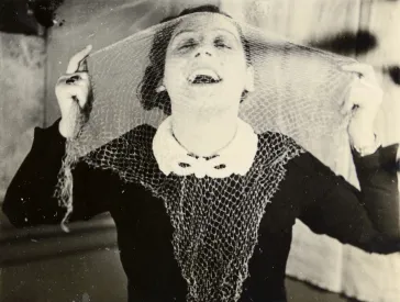 Portrait of a woman holding laces in front of her face