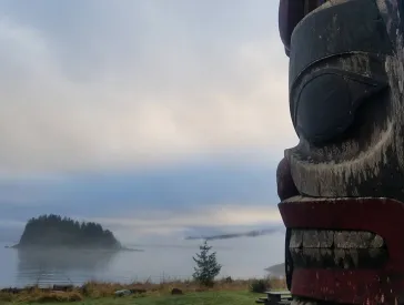 Photography of a totem pole in a foggy landscape with lake