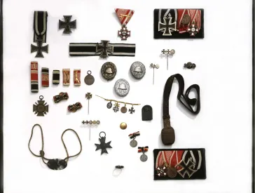 Assortment of objects including badges and pin, many of which have the Iron Cross