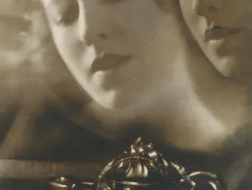 Black and white photograph of a woman whose face hovers ghost-like next to her.