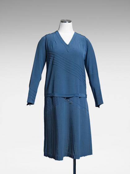 The image shows a blue twin set, including a shirt and a skirt.