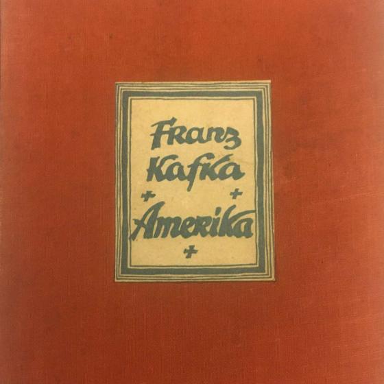 Ausschnitt aus einem roten Buchcover mit aufgeklebtem, gerahmtem Etikett mit der Aufschrift: „Franz Kafka, Amerika“.