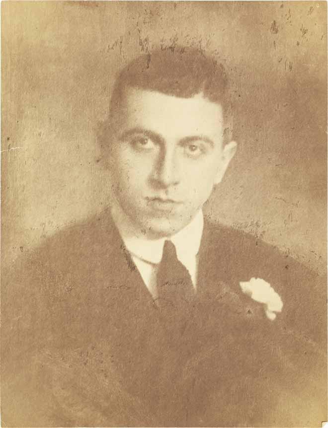 Black-and-white photograph: portrait of a young man in a suit and necktie