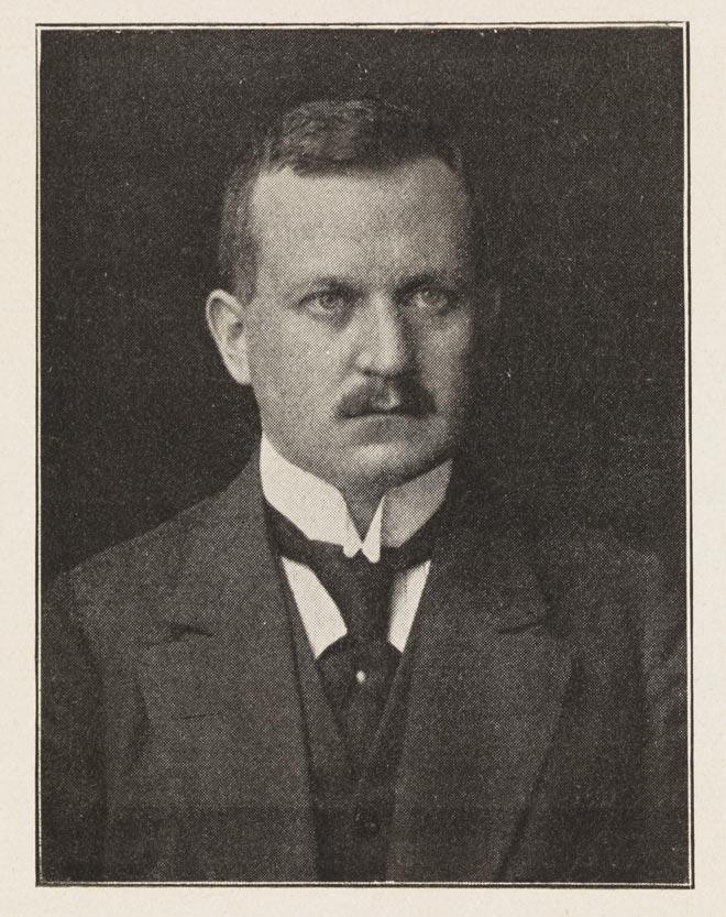 Black-and-white photograph: Man with moustache wearing a suit