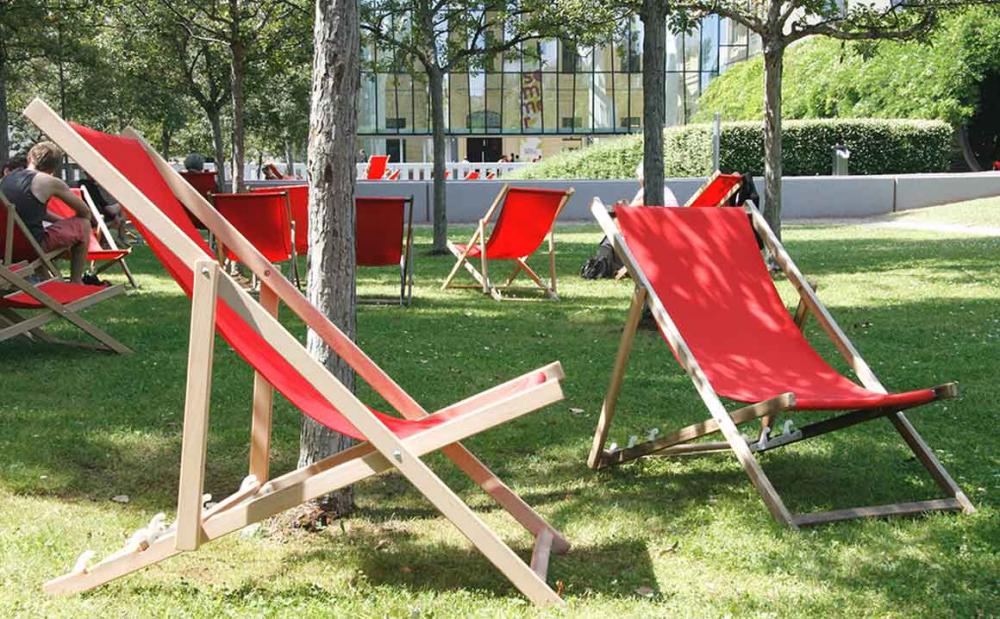 Red deckchairs in the garden of the Jewish Museum. The glass courtyard can be seen in the background.