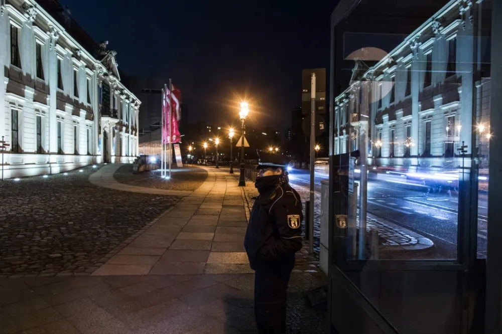 A Policewoman standing in front of the Museum at Night.