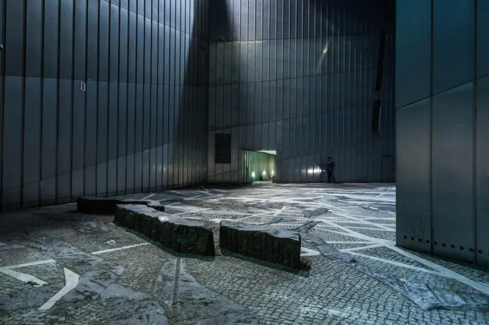 A view of the Paul-Celan-Hof of the Jewish Museum Berlin with a policeman walking along the far wall.