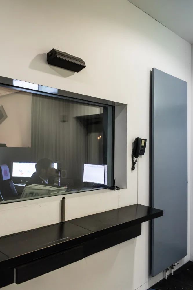 A security guard at his desk, leaning his head on his hand.