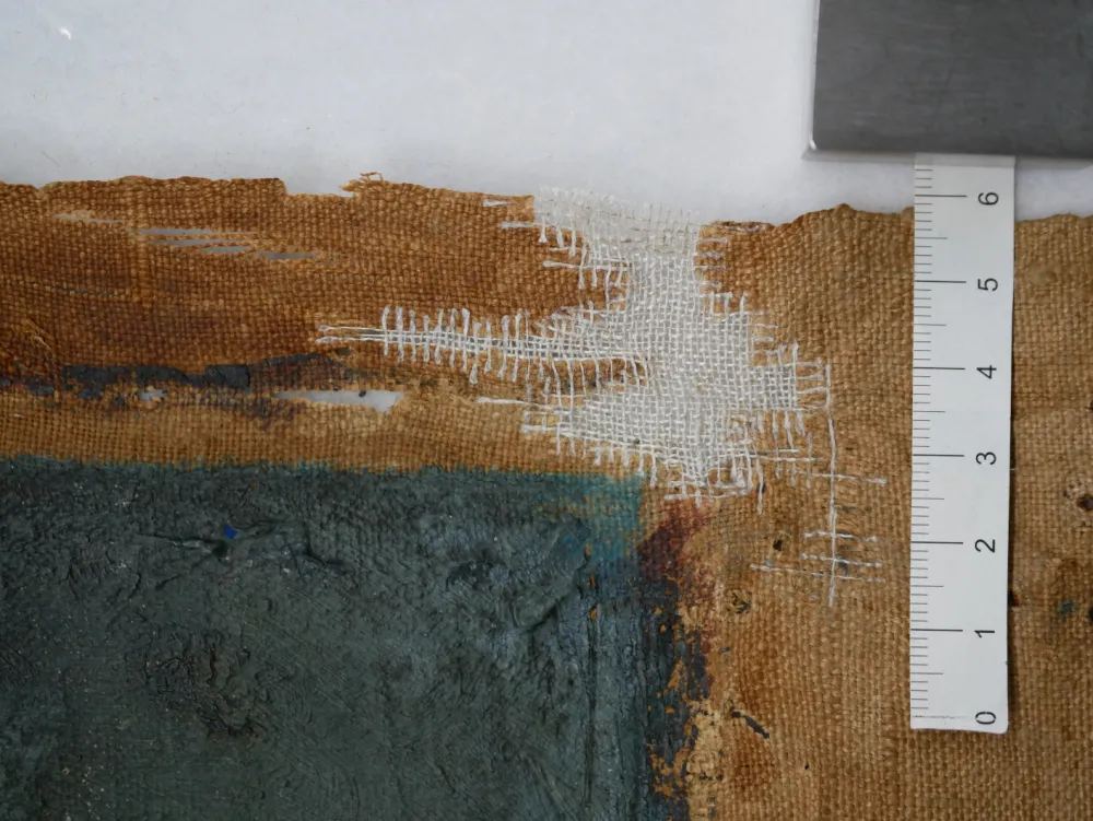 Close-up of the canvas with threads connected to the original fabric closing the holes
