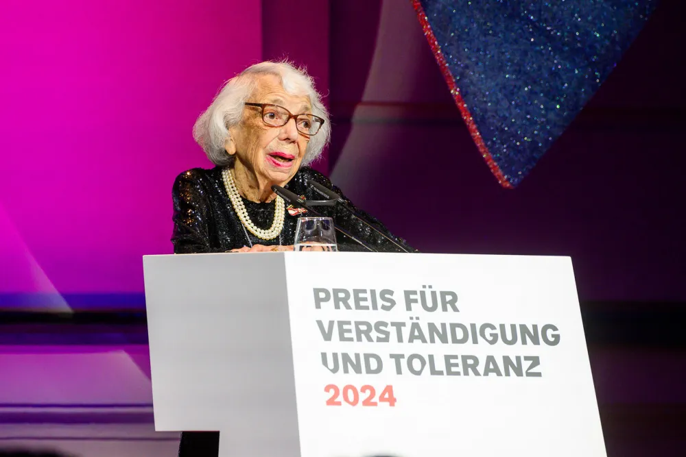 Eine Frau steht an einem Podium und hält eine Rede.