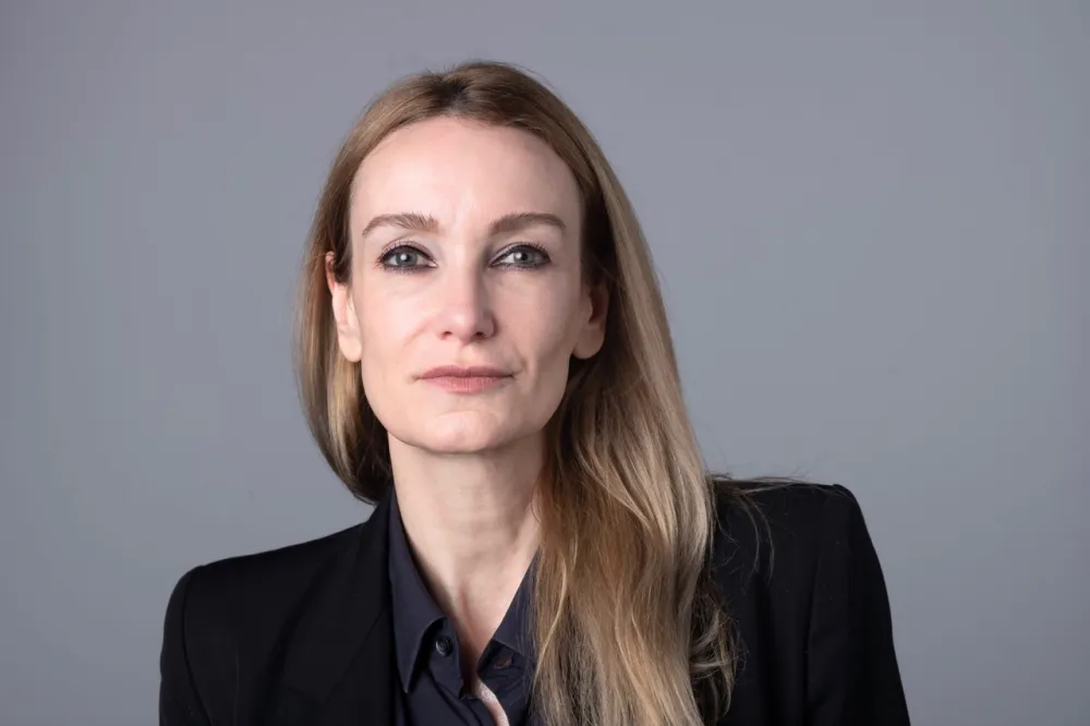 Portrait of a woman with long blonde hair looking into the camera.