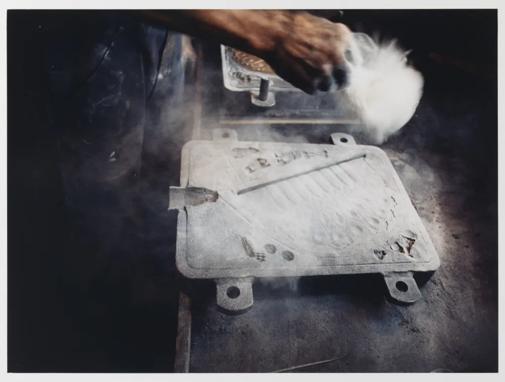 The mold of the Hanukkah lamp is dusted with charcoal dust and molding powder.