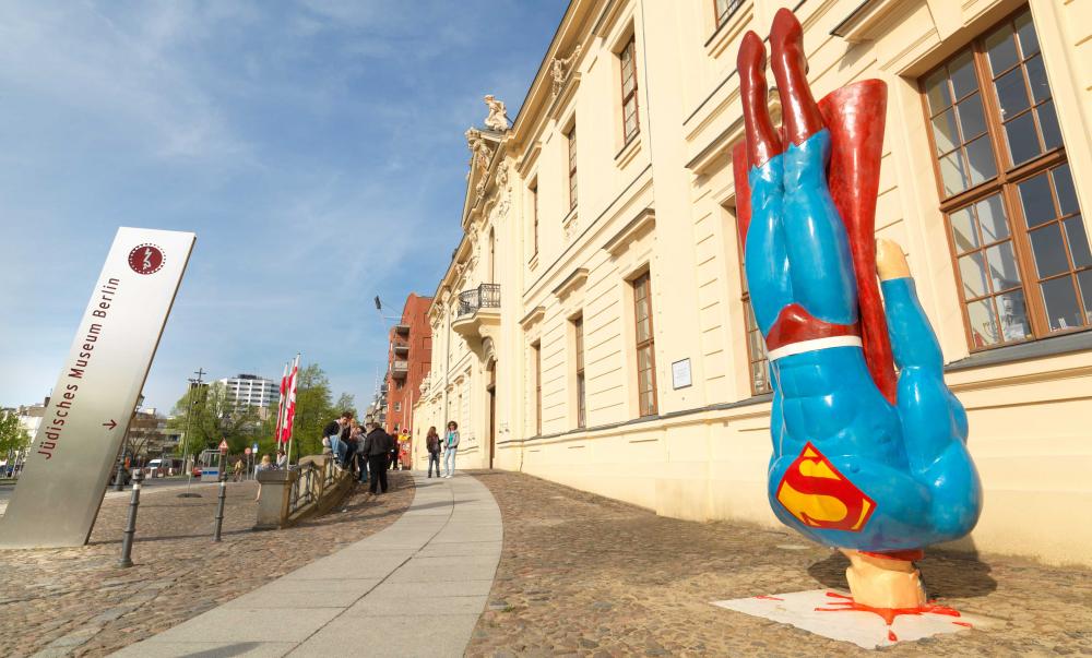 Skulptur, die Superman zeigt, wie er aus senkrechtem Flug auf dem Boden aufprallt